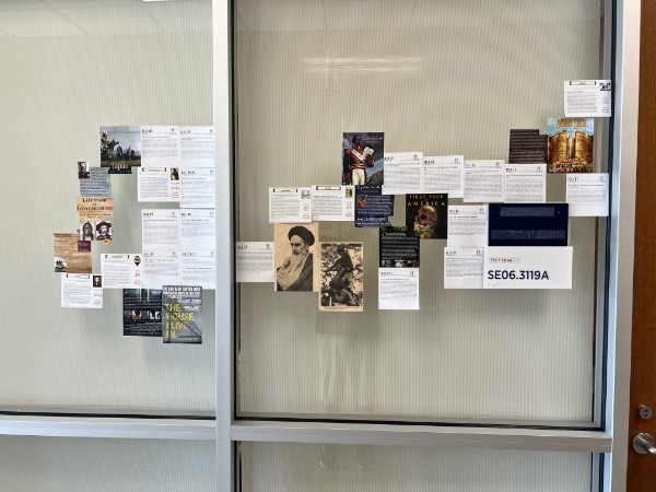 Book covers, portraits, and printed texts arranged in collages across two glass panels.