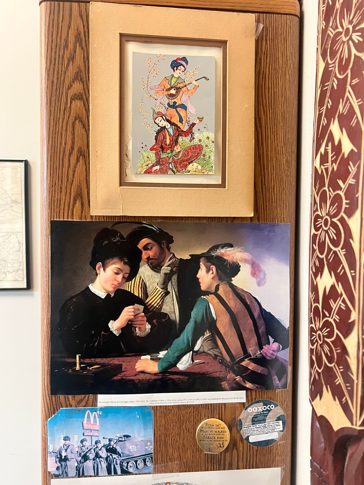 Art reproductions and a framed picture displayed beside a patterned hanging in the Center.