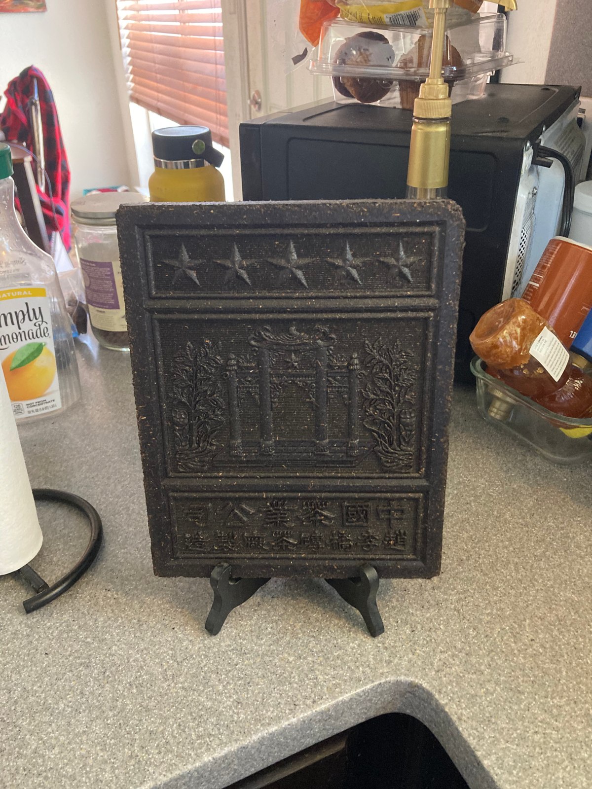 A decorated tea brick on a stand, labeled “A Brick of Chinese Tea” on the original Center page.