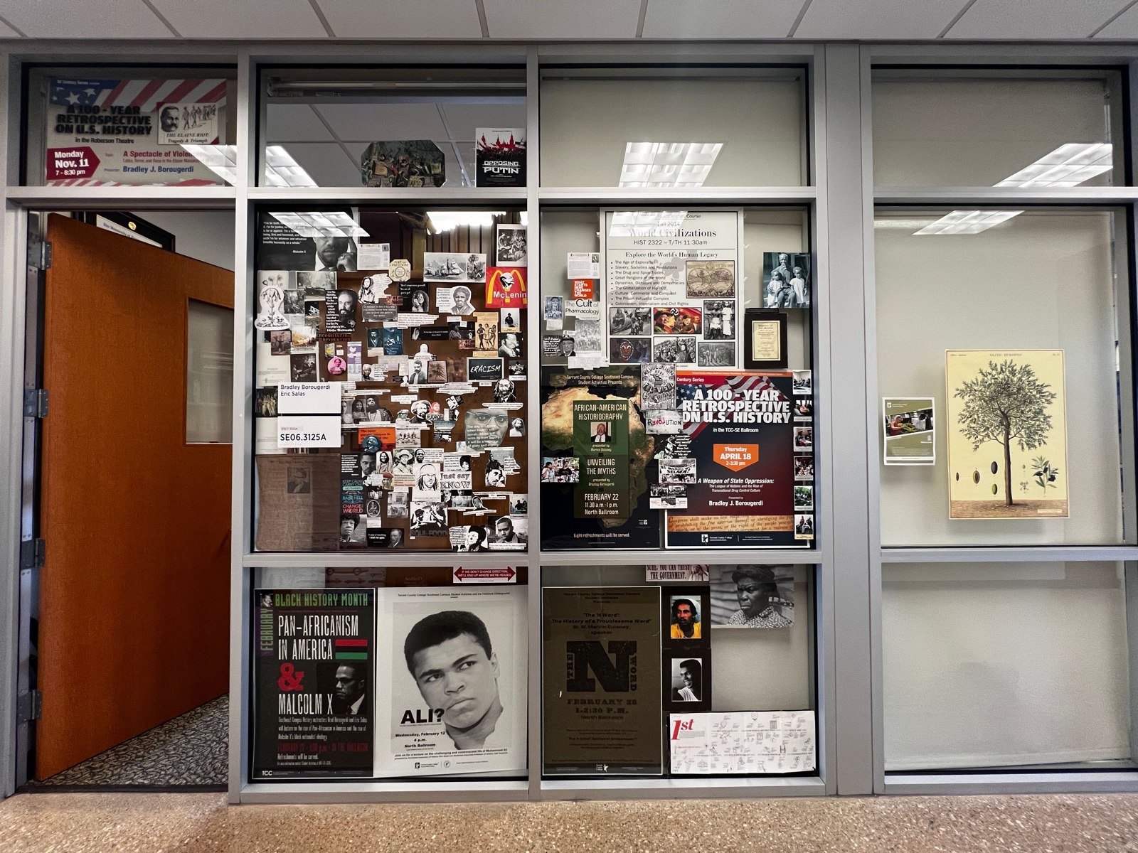 Photographs, quotations, and posters arranged across the Center’s glass wall.
